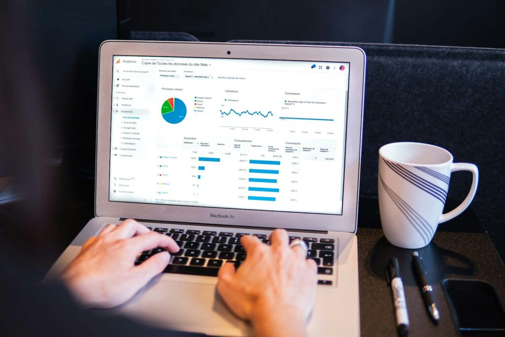 Portátil con un panel de analítica web junto a una taza de café